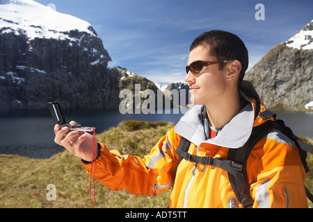 Hiker using compass in mountains Stock Photo