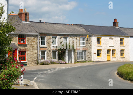 St Just in Roseland village mixed facards on row of vulnerable terraced cottages beside sharp bend on busy main road Cornwall England UK Stock Photo