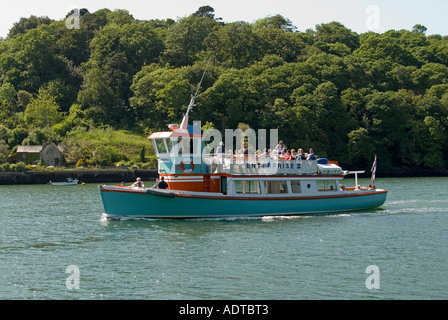 Trelissick river tour boat with passengers on Carrick Roads with woodland beyond Stock Photo