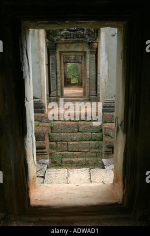 Internal corridors of famous Pre Rup temple viewed through an ancient stone doorway and dark mysterious corridor Angkor Cambodia Stock Photo