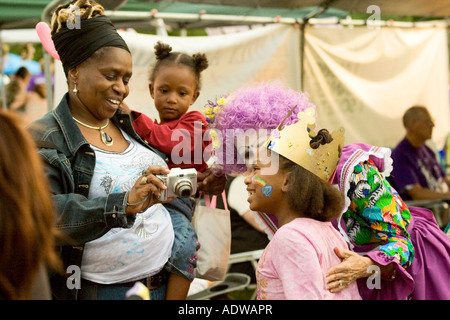 Woman looks at camera image as daughter has face painted by clowns at Relay for Life charity event in Ocala, Florida, USA Stock Photo