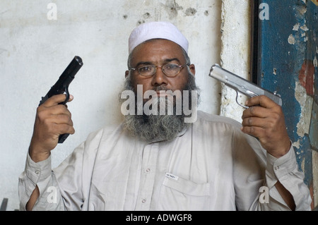 Traditional gunmaker in Darra Adam Khel Pakistan showing off two guns the original in black and the copy in silver Stock Photo