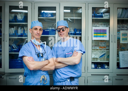 portrait of two 2 vascular surgeons wearing scrubs in operating room Stock Photo