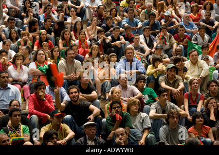 Portuguese football supporters, sitting in a shopping centre in Lisbon, watching the World Cup 2006 match versus Mexico on TV. Stock Photo