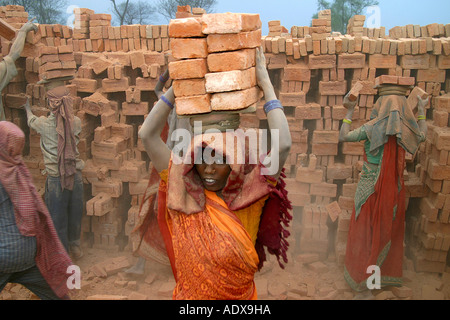 Women and children are doing heavy labour by working in stone factories Stock Photo