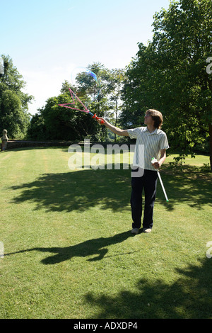 Man in mid twenty's blowing large bubbles outside using a bubble wand. Stock Photo