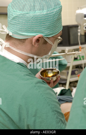 doctor holding metallic dish during surgery Stock Photo