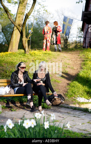 Two young Swedish women relaxing on a bench in a park in Gothenburg Sweden Stock Photo