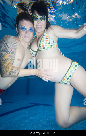 Pregnant Couple Swimming in Pool Couple therapy Stock Photo
