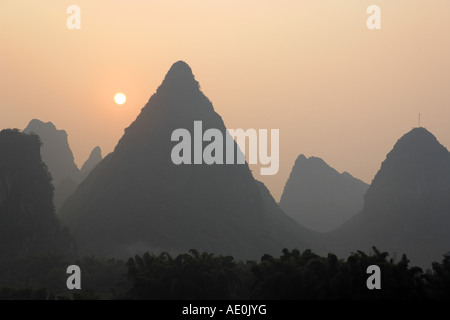 Sun rising over karst mountains Yangshuo Guanxi China Stock Photo