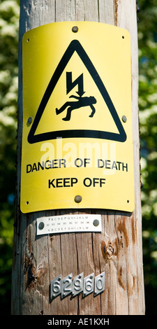 Danger of death Keep off sign onelectrical pole in the countryside Surrey England UK Stock Photo