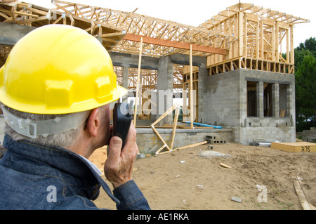 contractor on building site surveying construction progress Stock Photo