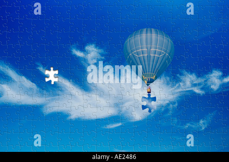 Jigsaw puzzle in the sky hot air balloon with missing piece concept Stock Photo