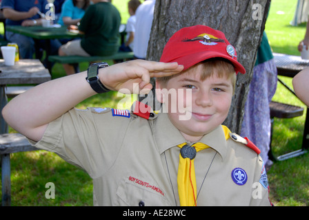 Boy scout in uniform performs three finger salute Stock Photo