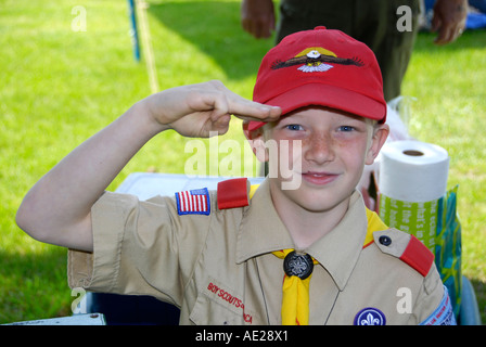 Boy scout in uniform performs three finger salute Stock Photo