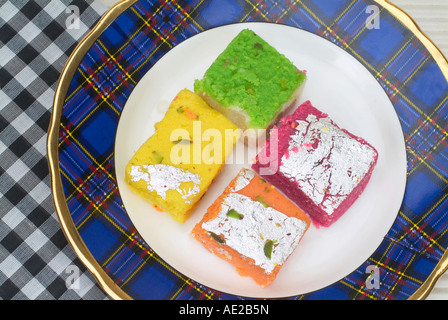 Four assorted barfi kept on a plate. Stock Photo