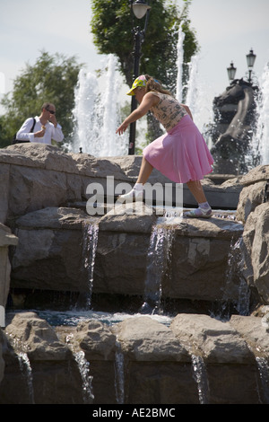 Child playing in the Four Horse Fountain in Alexander gardens near Manezhnaya square Moscow Russia Stock Photo