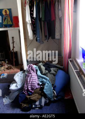 Messy piles of clothes in teenage boy's bedroom Stock Photo