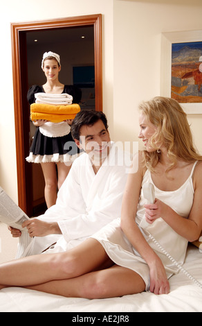 Couple on bed in hotel room Stock Photo