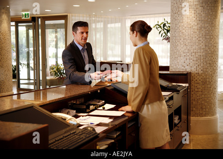 Man checking in at the hotel reception desk Stock Photo