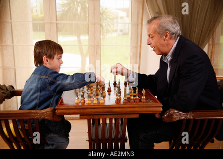 Mature man and little boy playing chess Stock Photo