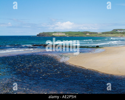 River Bush flows into sea at Bushfoot, Portballintrae near Bushmills on the Runkerry Trail. Giants Causeway cliffs in distance Stock Photo