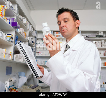 pharmacist in a white lab coat examines a bottle of medication while holding a checklist Stock Photo