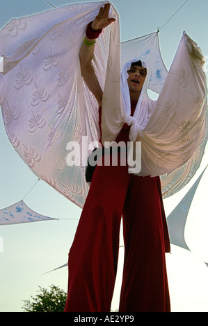 Hilltop 2006 - slender boy with white veil dancing at rave party on stilts Stock Photo