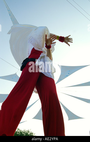 Hilltop 2006 - slender boy with white veil dancing at rave party on stilts Stock Photo