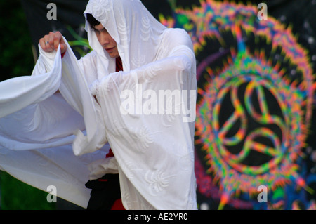 Hilltop 2006 - slender boy with white veil dancing at rave party in front of  psychedelic mandala Stock Photo