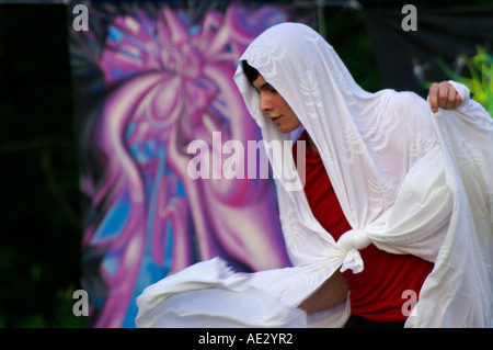 Hilltop 2006 - slender boy with white veil dancing at rave party in front of  psychedelic mandala Stock Photo