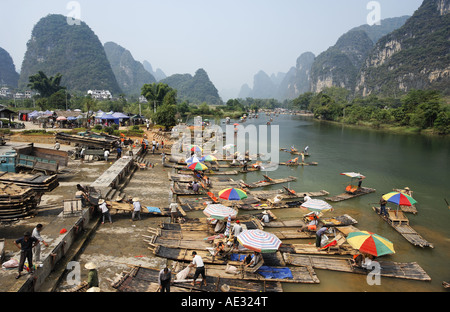 Bamboo tourist rafts being pulled out of Yulang River and put on trucks Yangshuo Guanxi China Stock Photo