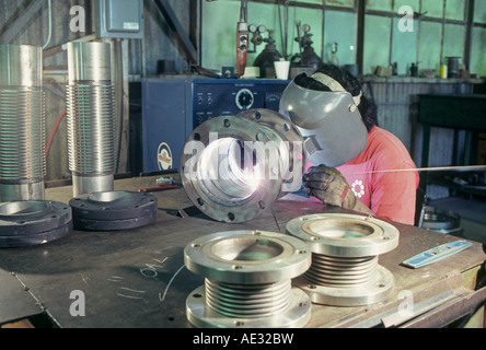 A union welder using an arc welder welds pipes in together in a shop in Little Rock Arkansas Stock Photo