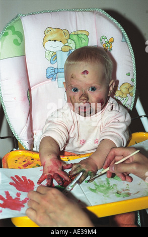 Baby of 7 months old is painting with mother. Russia Stock Photo