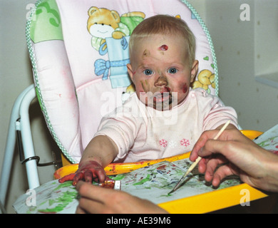 Baby of 7 months old is painting with mother. Russia Stock Photo