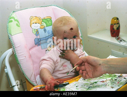 Baby of 7 months old is painting with mother. Russia Stock Photo