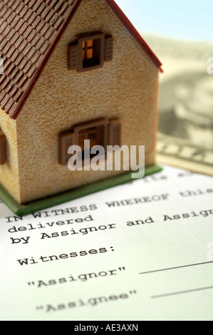Miniature house and dollar banknote on a contract Stock Photo