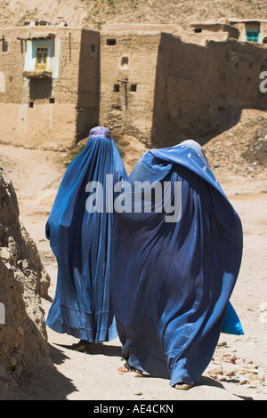 Ladies wearing burqas walk towards houses inside the ancient walls of Citadel, Ghazni, Afghanistan, Asia Stock Photo
