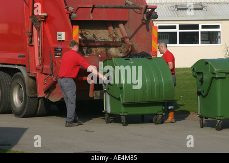 Man emptying commercial size dustbin into a lorry with automatic equipment Stock Photo