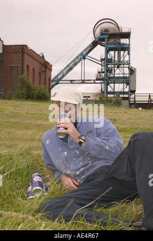 an unemployed man gets drunk in front of the abandoned Haig coal pit in Whitehaven Cumbria Stock Photo