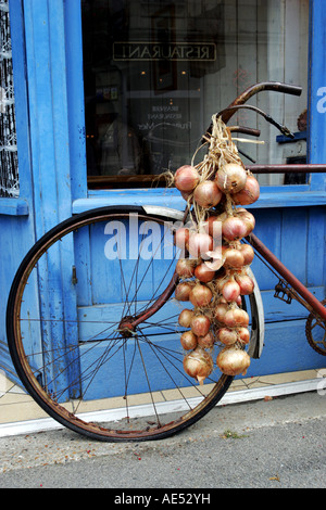 An onion seelers bike ouside a traditional french creperie in the Brittany coastal town of Roscoff Stock Photo