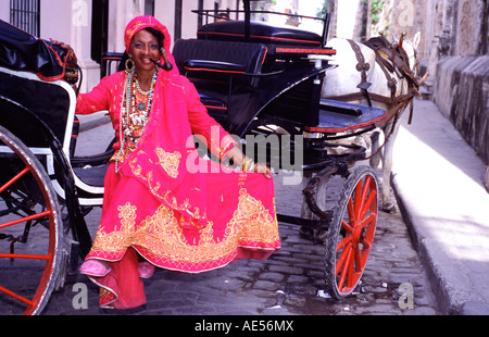 Cuban woman wearing flanboyant clothes in Old Havana Seating on a carriage She is wearing earings and many necklaces and is smok Stock Photo