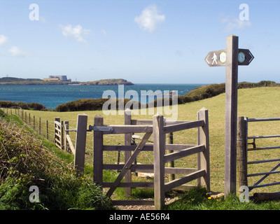 Isle of Anglesey Coastal Path sign and kissing gate with Cemaes Bay on northern coast beyond. Anglesey North Wales UK Stock Photo