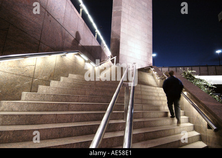 Man walking up steps at night, London England UK Stock Photo