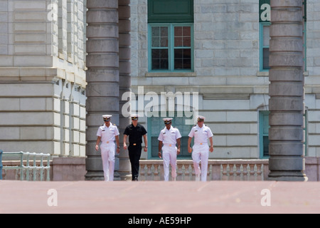 Four male sailors in blue and white service uniforms walking on campus of the United States Naval Academy - Annapolis Maryland Stock Photo