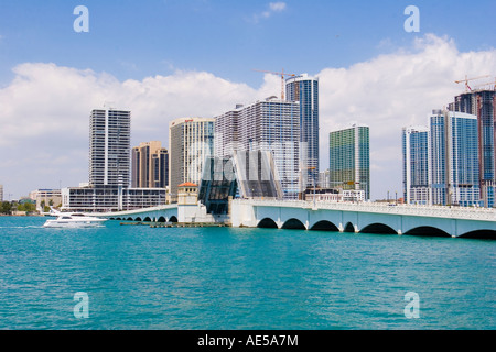 Yacht in Biscayne Bay approaching raised drawbridge of Venetian Way bridge with the Miami skyline - Florida Stock Photo