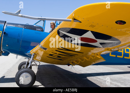 Pilot sitting in cockpit of army Vultee BT 13 Valiant as seen from under wing parked on the tarmac at an air show Stock Photo