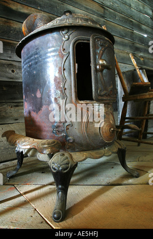 Old rusted antique wood burning stove with door partially open Stock Photo