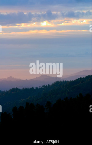 The Sun Sets Through Layers Of Clouds As People Walk Along The the-sun-sets-through-layers-of-clouds-as-people-walk-along-the