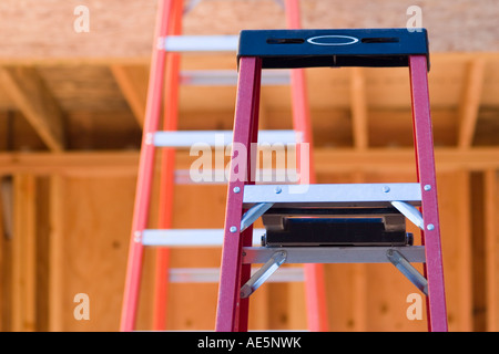 Two ladders at a construction site inside a room being framed as part of a home construction project Stock Photo